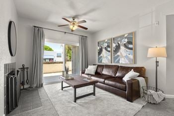 A living room with a couch and a ceiling fan